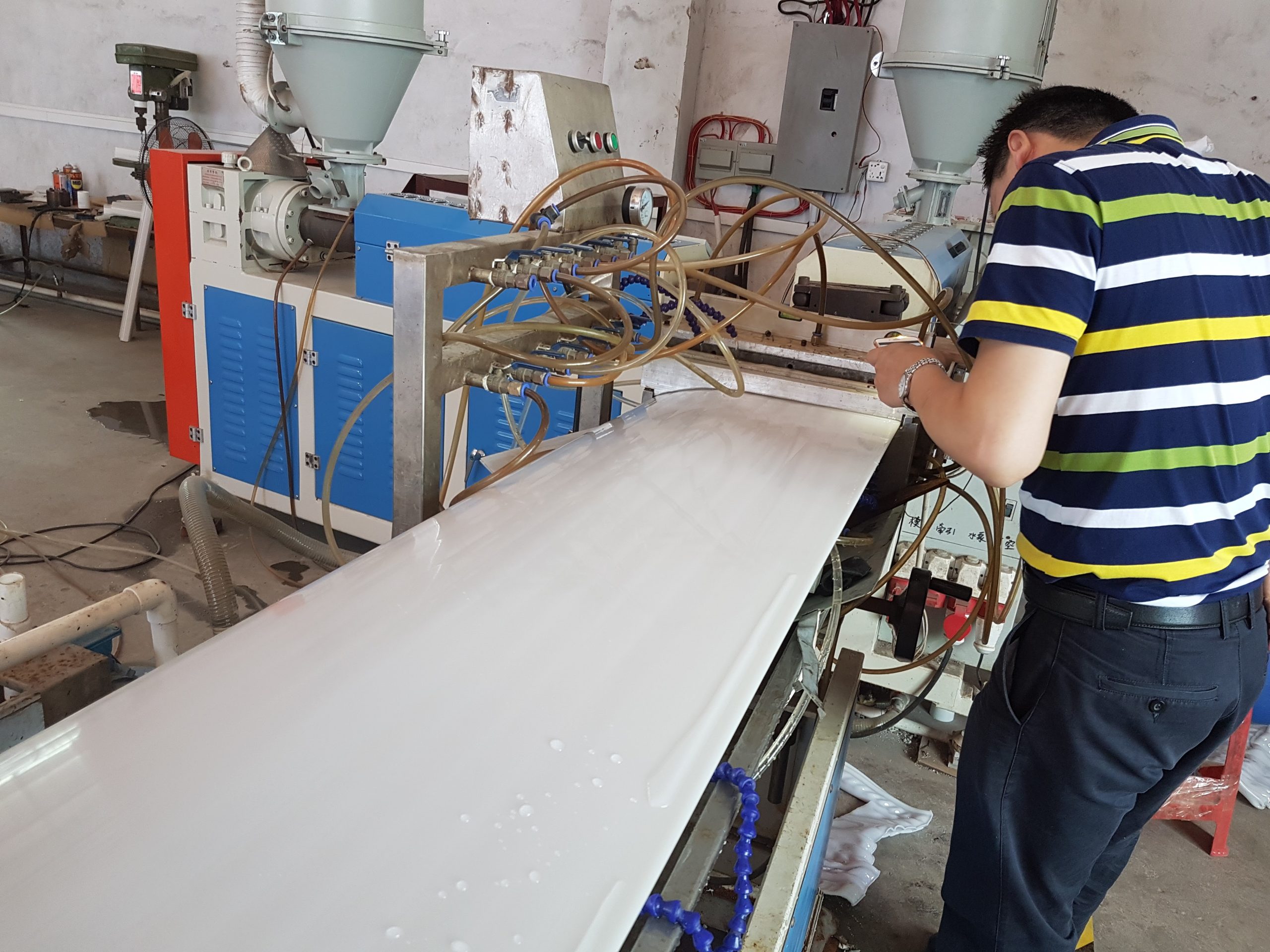 A factory worker using machinery to manufacture a custom cabinet door.