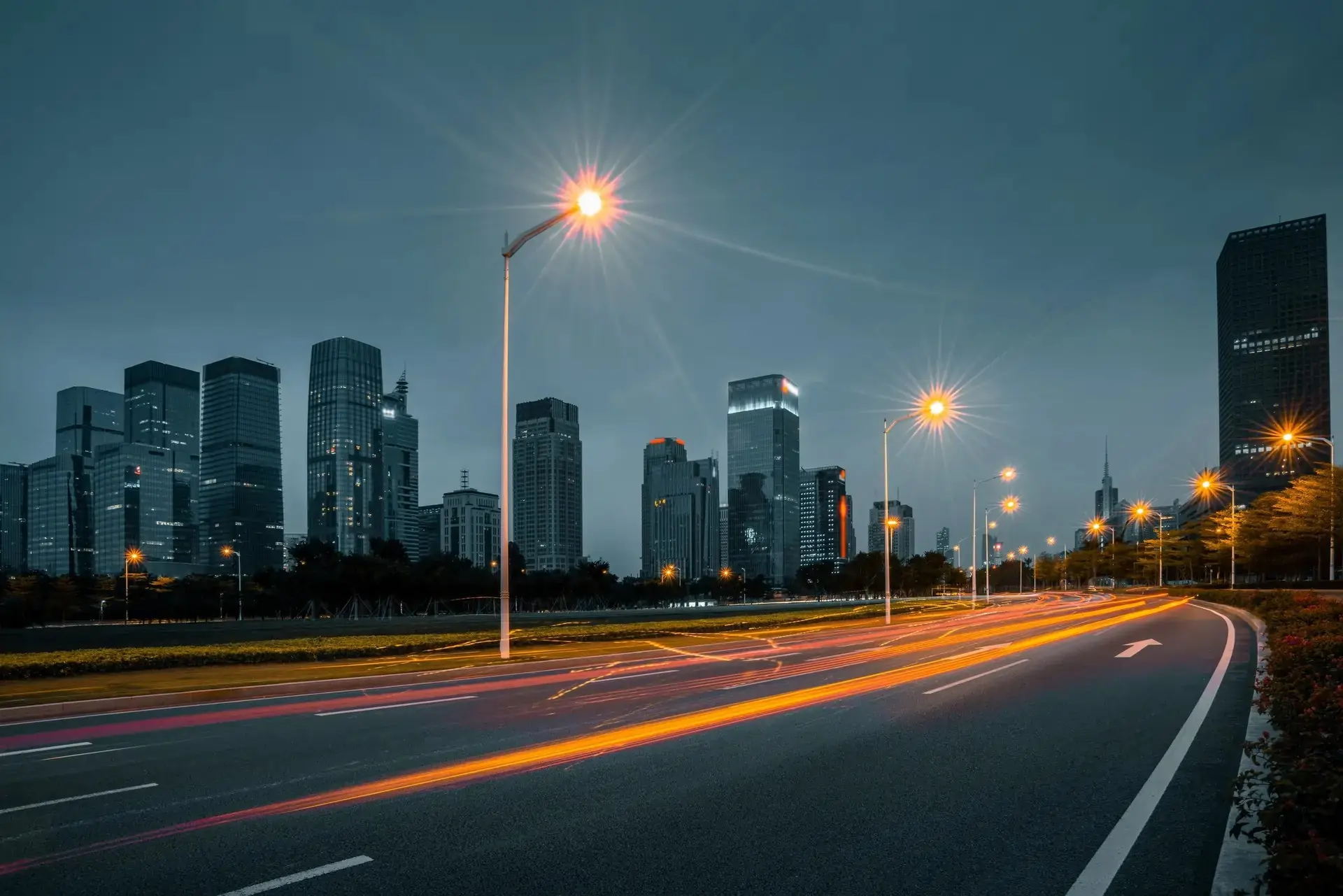 Long exposure photo of car light trails on a highway at night, showcasing vibrant streaks of red and white lights.